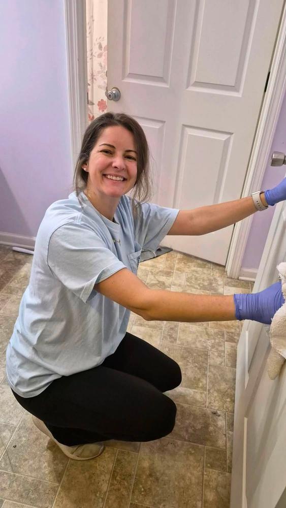 A volunteer cleaning a doorway