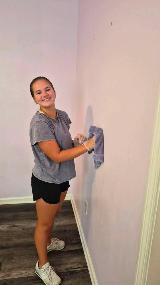 A volunteer cleaning a bathroom