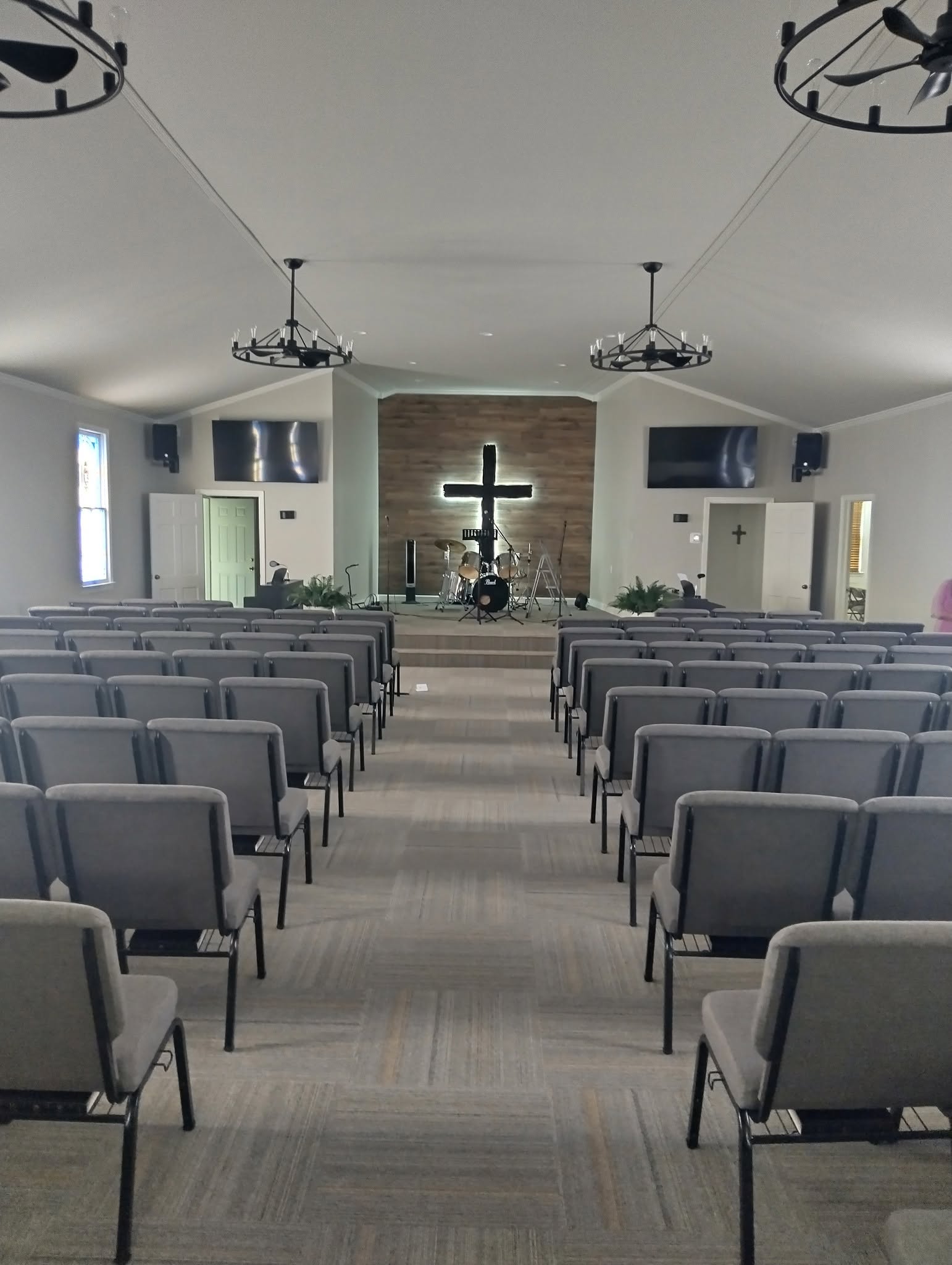 Inside the Wesley Chapel sanctuary — rows of chairs facing a lighted cross on a wood accent wall
